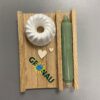 Auf einem Holzbrett liegt eine Kerze neben einem Gugelhupf aus Gips mit dem Schriftzug "Gronau" verziert.