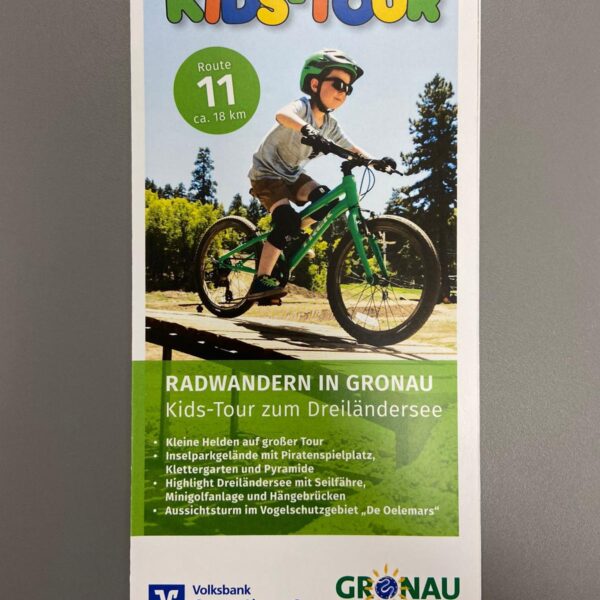 Vorderseite der Radwanderflyers Kids-Tour zum Dreiländersee. Auf dem Bild ist ein Kind auf einem Fahrrad zu sehen.