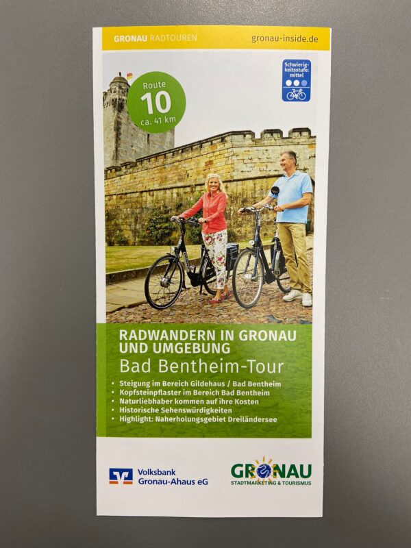 Vorderseite des Radwanderflyers "Bad Bentheim-Tour". Zu sehen sind zwei Radfahrer vor der Burg.