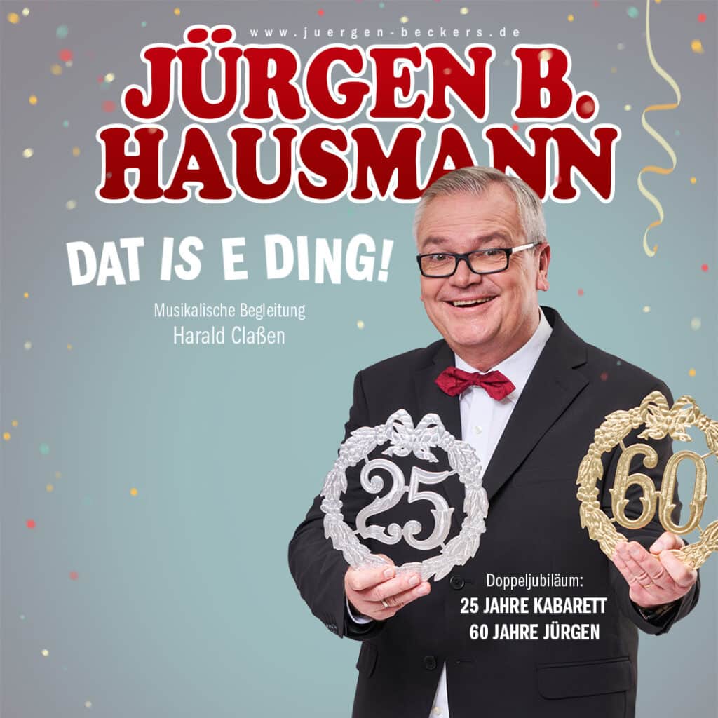 Jürgen B. Hausmann, in einem schwarzen Smoking mit roter Fliege um den Hals. In der Hand eine Jubiläums "25" und Jubiläums "60".