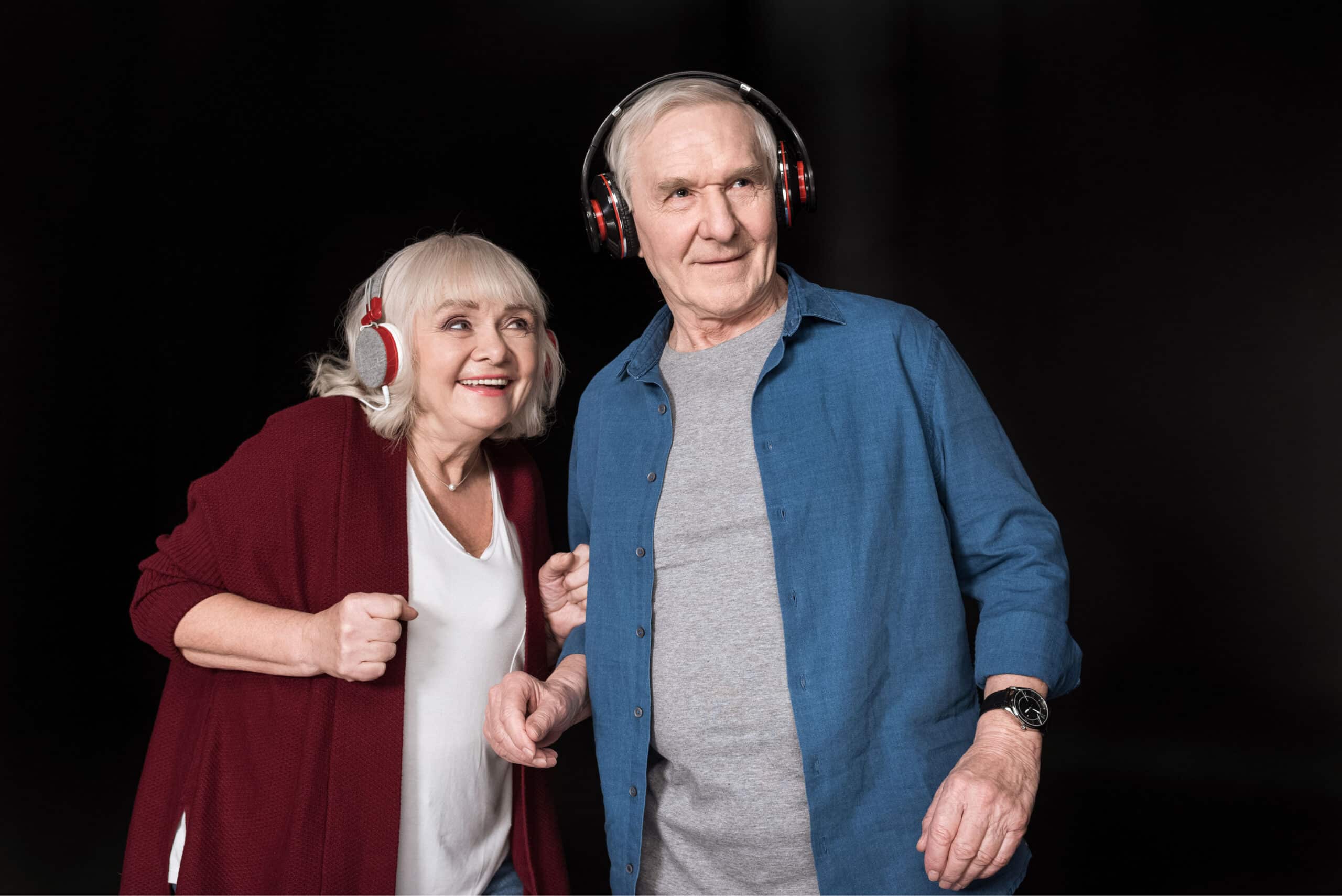 Ein Bild mit einer älteren Dame und einem älteren Herren, die Musik hören