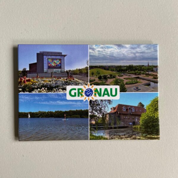 Der rechteckige Magnet zeigt vier Motive in Gronau: oben links das rock'n'popmuseum in frühlingshafter Kulisse, oben rechts das Laga-Gelände aus der Vogelperspektive, unten links den Dreiländersee und unten rechts Schepers Mühle im Ortsteil Epe. In der Mitte ist der Schriftzug "Gronau" zu lesen.