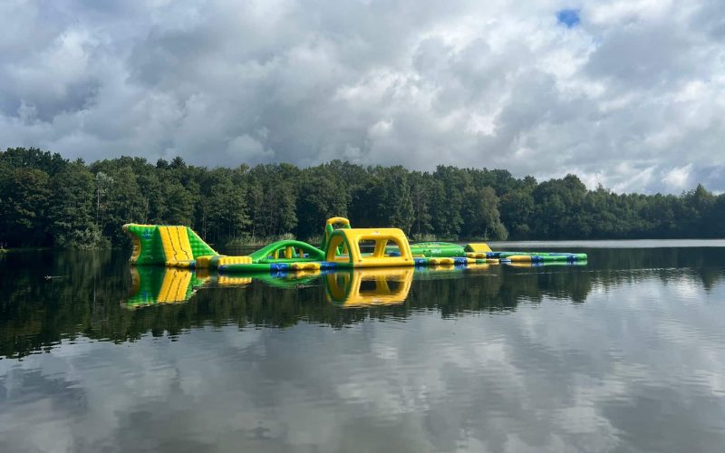 The picture shows part of the Dreiländersee. A fitness course is set up on the lake.