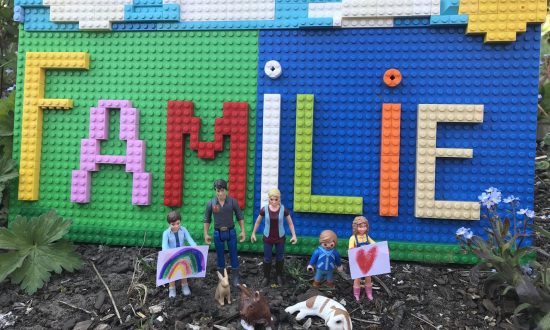 Auf dem Bild zu sehen ist ein Kunstwerk aus Lego. Aus Lego wurde der Schriftzug Familie gebastelt.