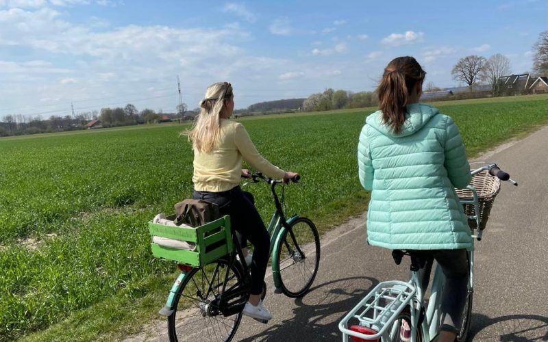 Zwei Frauen sind von hinten auf den Fahrrädern zu sehen.